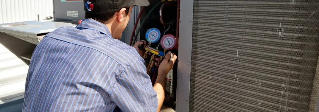 HVAC technician servicing a condenser unit in Beckett Ridge