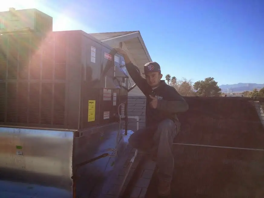 HVAC technician performing AC Tune-Up on a rooftop unit in Beckett Ridge